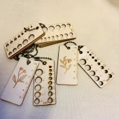 Pinnemåler med lyst tre og messing