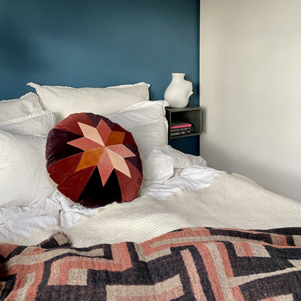 Seng som er redd opp med fargerik pute og pledd