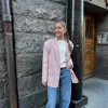 Jente i rosa blazer med hvit genser inni og lyse jeans til