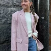 Jente i rosa blazer med hvit genser inni og lyse jeans til