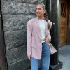 Jente i rosa blazer med hvit genser inni og lyse jeans til