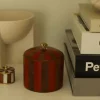 Doing Goods, Piper Cicus Box Large. En stripete rød og brun stor boks og en liten brun og hvit boks med lukk og messing detaljer. Plasser på. en hylle med bøker ved siden av